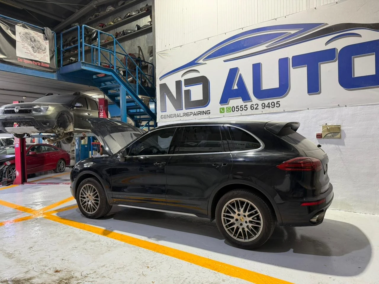 Black Porsche Cayenne inside ND Auto General Repair workshop
